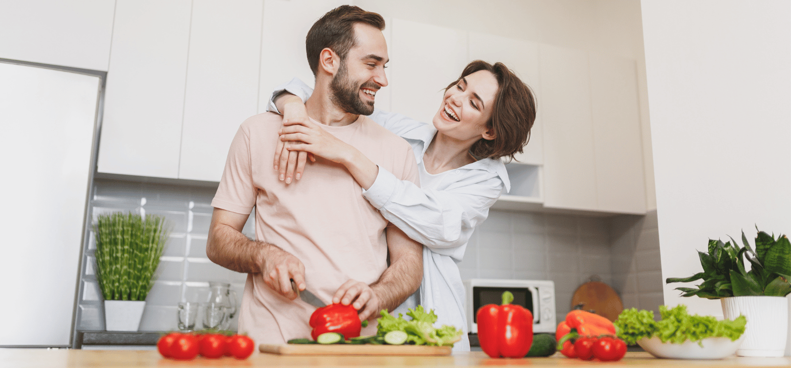 Smiling couple standing in kitchen.