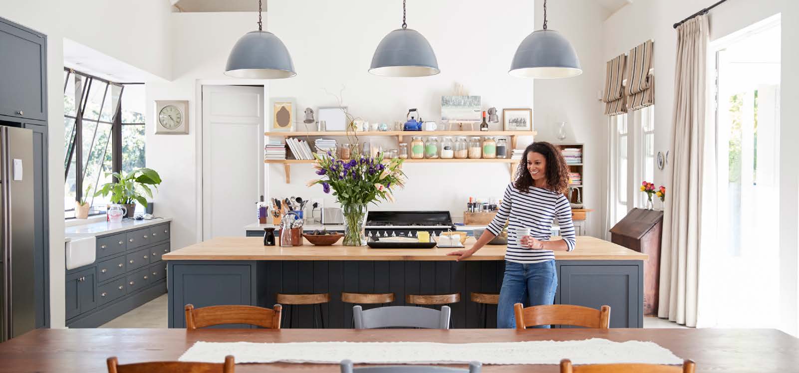 Smiling woman standing in front of kitchen counter.