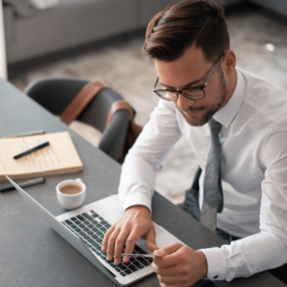 a businessman working on his laptop holding a credit/debit card