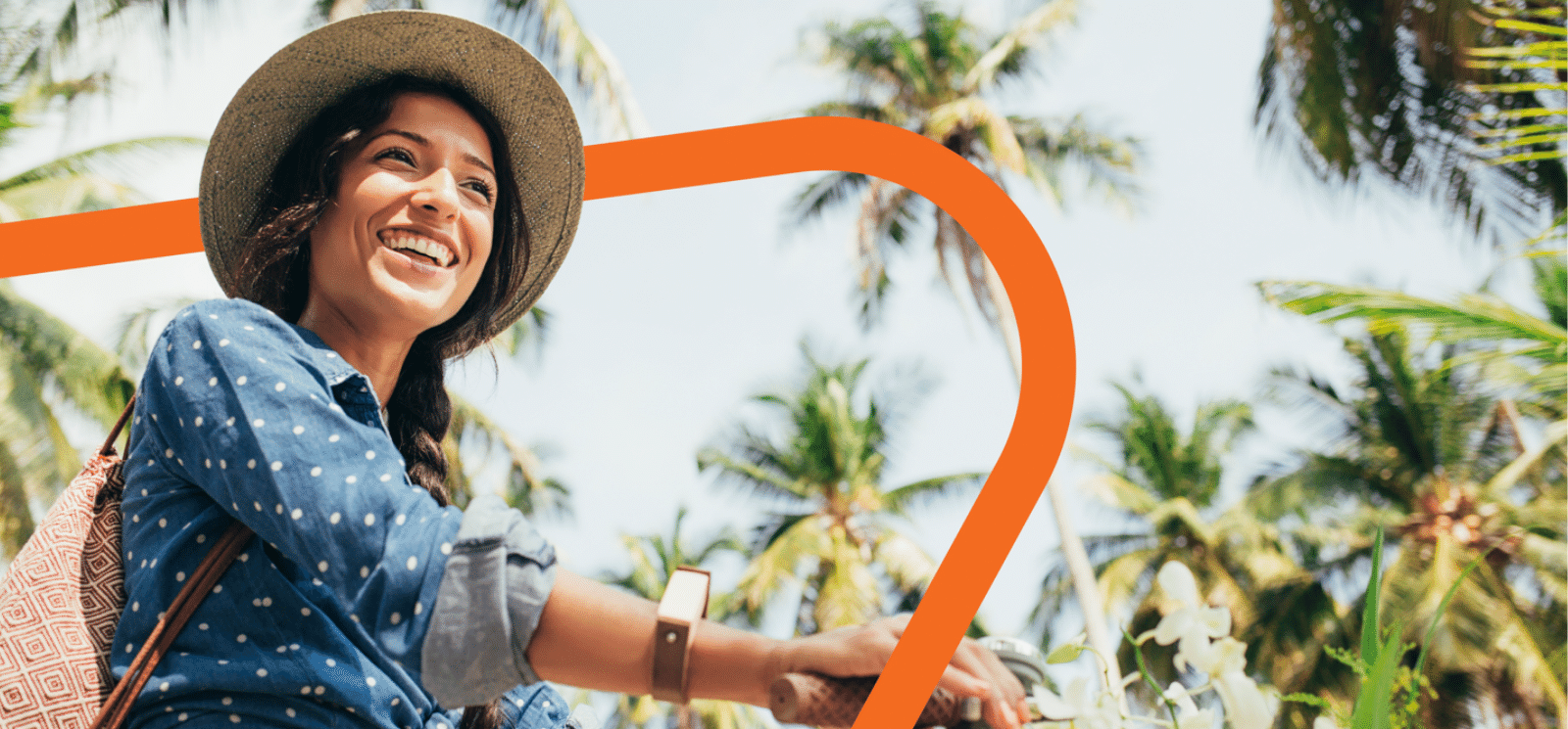 Smiling woman on a bike with palm trees in the background.