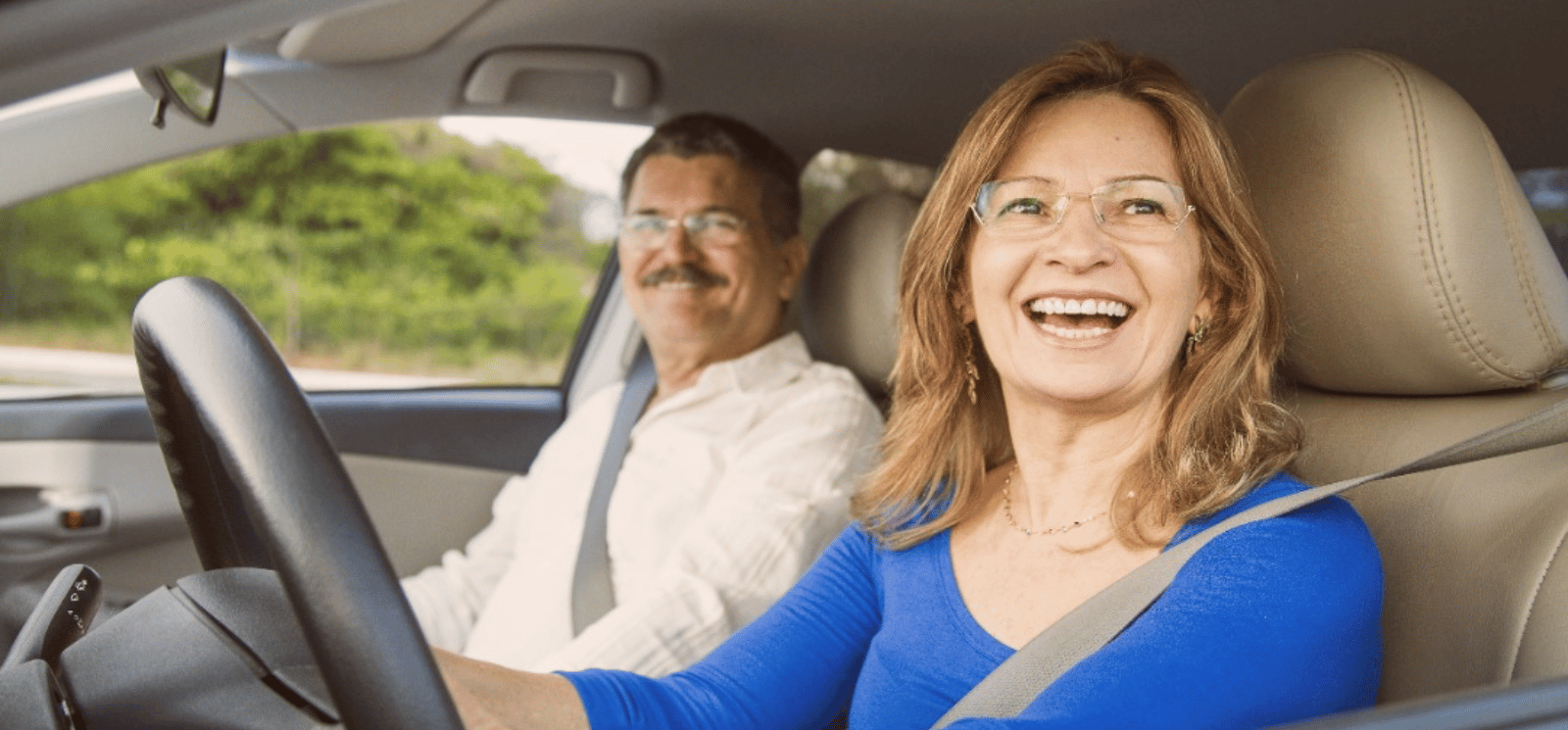 Couple sitting inside car and smiling