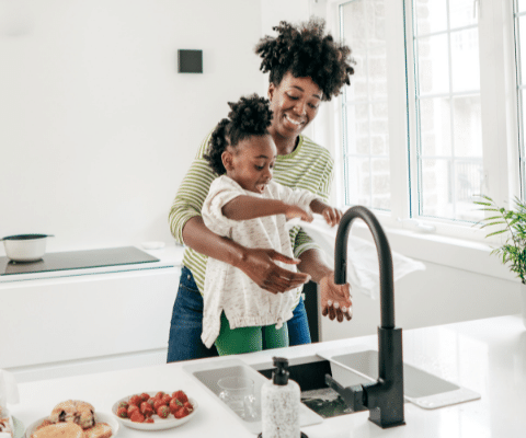 Mother and child in the kitchen using the kitchen sink