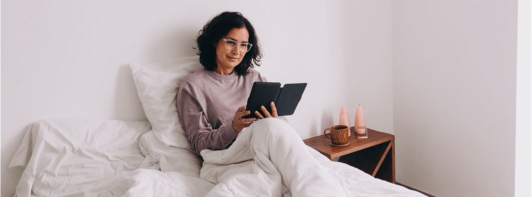 woman sitting on bed reading