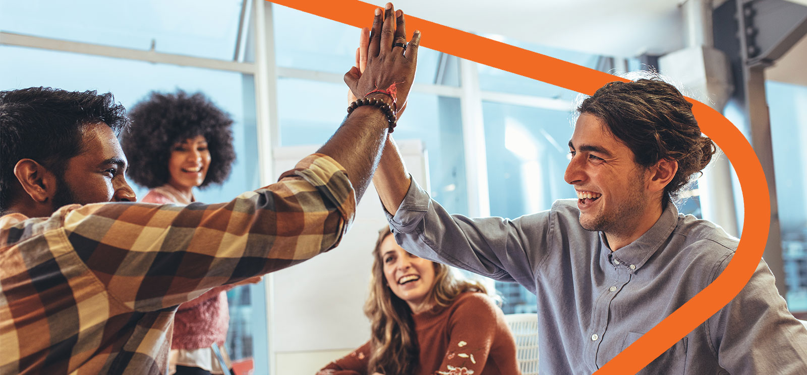 Two friends smiling and high-fiving while two friends are watching