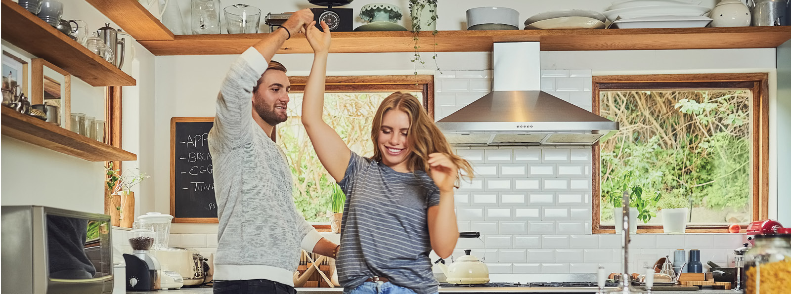Smiling couple dancing in the kitchen.