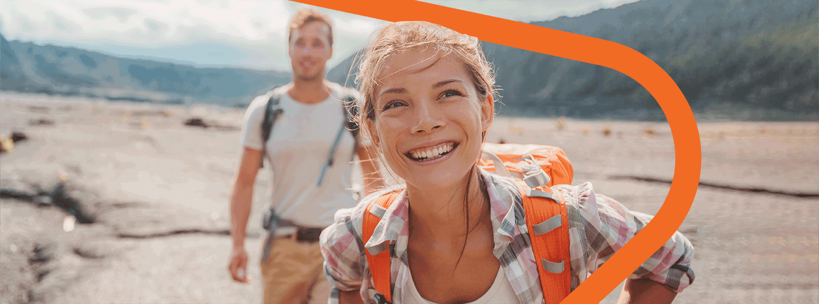 Man and woman smiling while hiking.