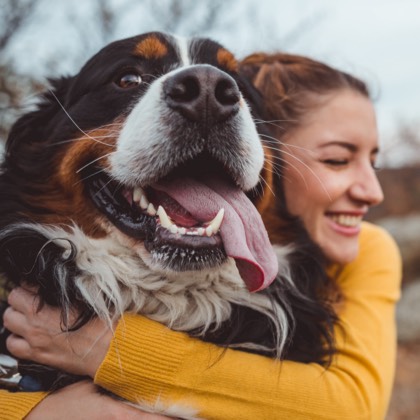 A woman embracing a large dog.