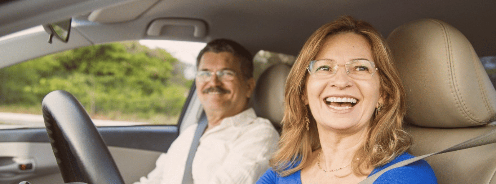 Couple sitting inside car and smiling