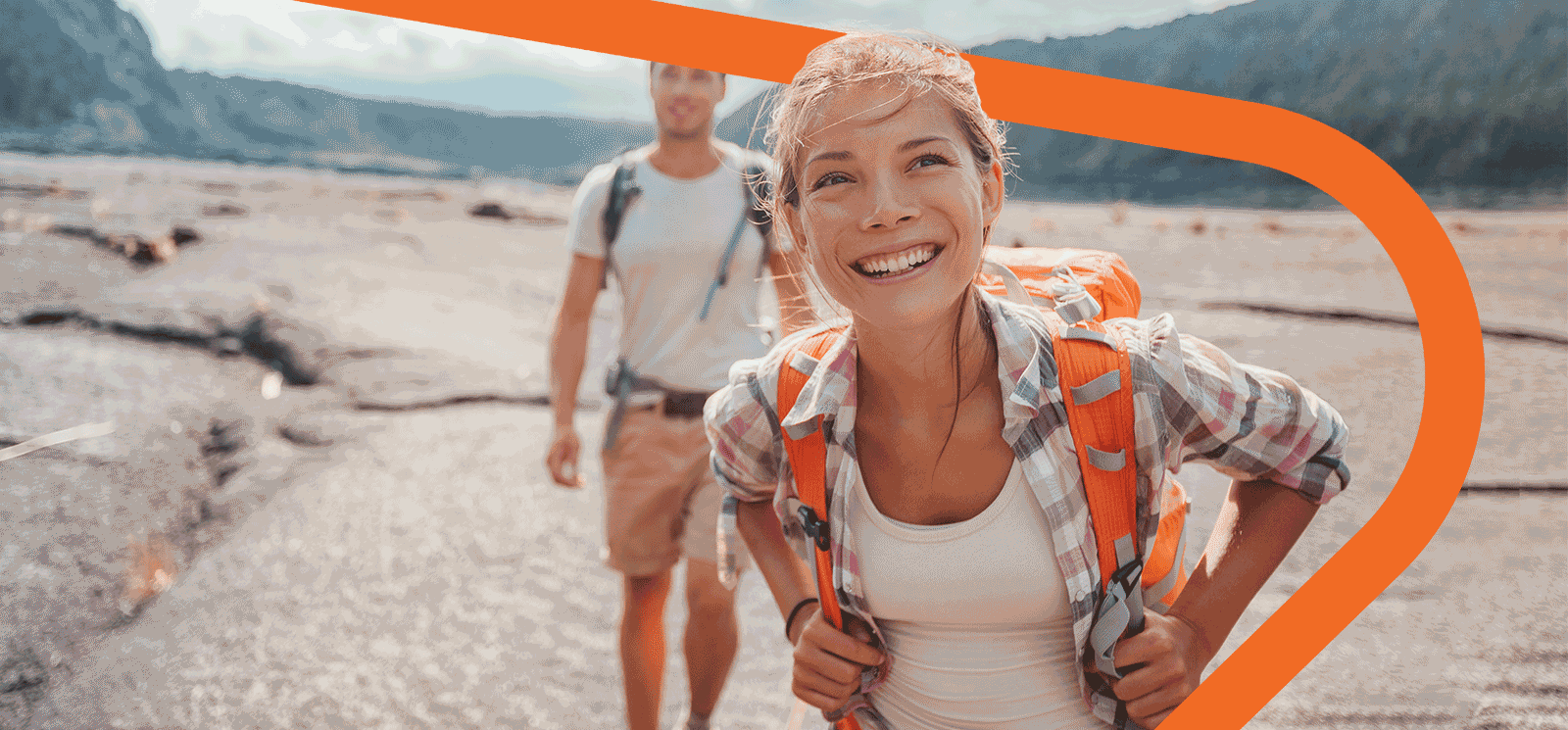 Man and woman smiling while hiking.