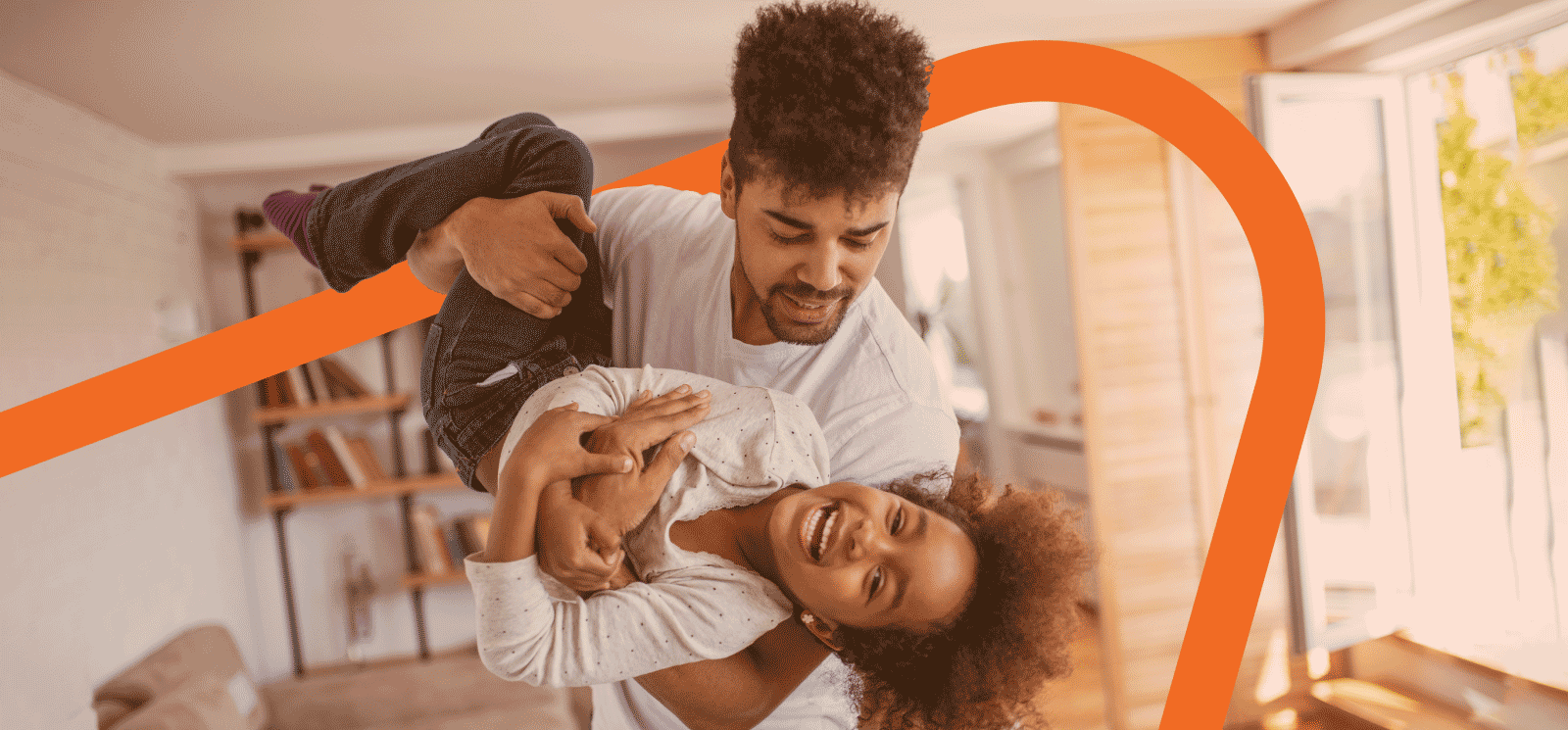 Smiling father holder smiling child while playing.