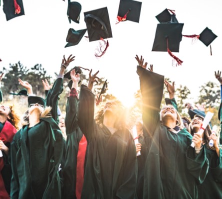 A group of graduates throwing their caps in the air.