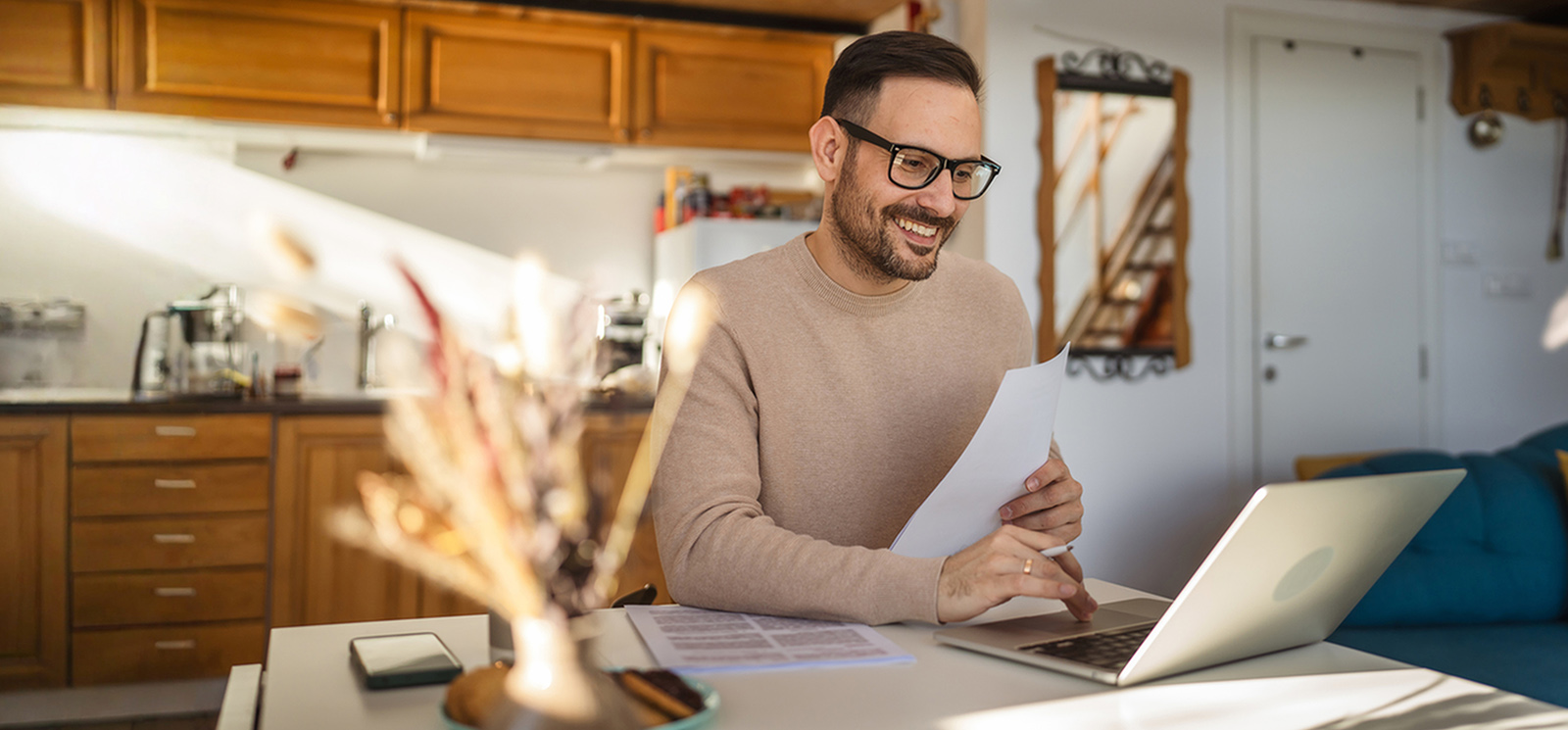 Smiling man sitting infront of a laptop computer.