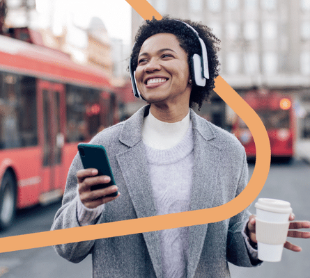 Smiling woman wearing a headset and holding a cell phone.