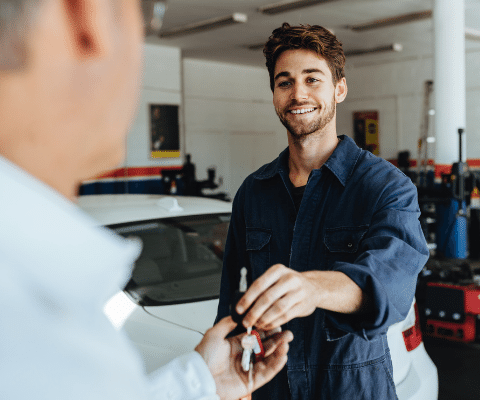 Auto mechanic handing keys to a customer